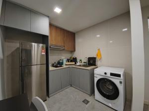 een keuken met een koelkast en een wasmachine bij The Ooak Suites @ 163 Building (Mont Kiara) in Kuala Lumpur