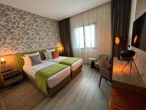 Hotel Ben Batouta - Tanger في طنجة: غرفه فندقيه بسرير ونافذه +37 صورة