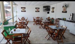 a room with tables and chairs in a restaurant at Pousada Pescador in Ubatuba