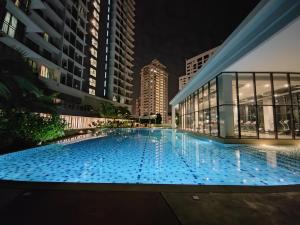 a large swimming pool in a building at night at The Ooak Suites @ 163 Building (Mont Kiara) in Kuala Lumpur