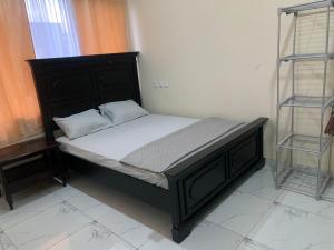 uma cama com uma cabeceira preta e lençóis brancos em Luxury for you em Acra