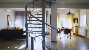uma escada em espiral numa sala de estar com uma mesa em Lovely Sunset -Villa Zoe em Nea Moudania