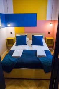 a bedroom with a large bed with blue pillows at HOLI in Toruń