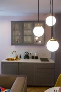 a kitchen with a sink and a counter with lights at HOLI in Toruń