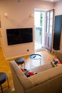 uma sala de estar com um sofá e uma televisão de ecrã plano em HOLI em Toruń