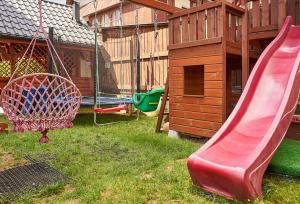 a playground with a slide and a play house at Willa Sichelscy in Biały Dunajec