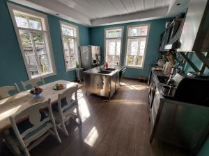 una cucina con pareti blu, tavolo e piano cottura di Musala 1 Bed & Breakfast a Kjustendil