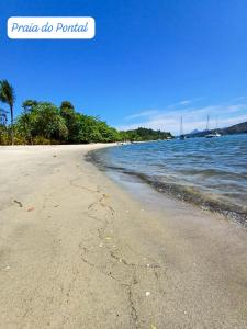 piaszczysta plaża z drzewami i wodą w obiekcie A S Suites w mieście Angra dos Reis