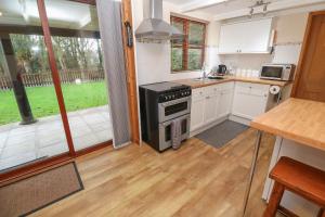 a kitchen with a stove top oven next to a window at Demelza in Truro