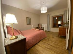 Auberge de Corsas في Saint-Victor: غرفة نوم بها سرير ومصباح على طاولة +5 صور