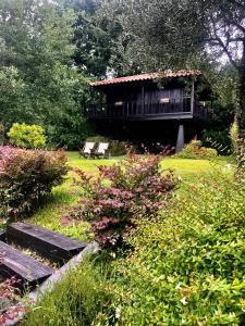 a house with a deck and benches in a garden at Quinta Lamosa Agroturismo in Arcos de Valdevez