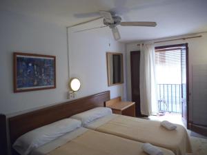 a bedroom with two beds and a ceiling fan at Casa de Huespedes la Peña in Ibiza Town