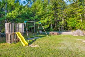 a playground with a slide in the grass at Mersey River Chalets a nature retreat in Caledonia
