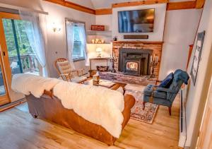 a living room with a couch and a fireplace at 5 bdrm Creekside Chalet located near 4 ski resorts in Weston