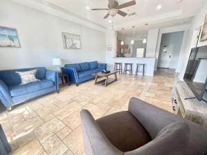 a living room with blue couches and a kitchen at Vistalmar Beach Resort in Deerfield Beach