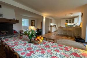 ein Wohnzimmer mit einem Tisch und einer Obstschale darauf in der Unterkunft La maison aux volets blancs in Beaux
