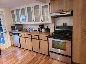 La cuisine est équipée de placards blancs et d'un four avec plaques de cuisson. dans l'établissement Appartement condo dans le vieux Québec, à Québec