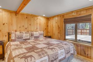 a bedroom with a bed with wooden walls and a window at Black Bear Hideaway in South Lake Tahoe