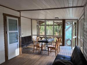 a screened in porch with a table and chairs at Konopka Forest Home & SPA in Bukovel