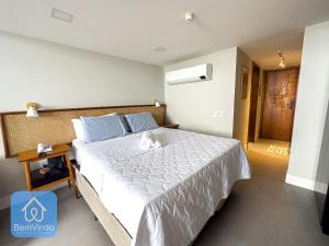 ein Schlafzimmer mit einem großen Bett mit einer weißen Tagesdecke in der Unterkunft Apartamento na Vitória com Pier e acesso ao mar in Salvador