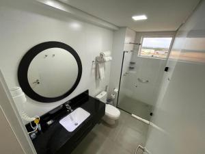 a bathroom with a mirror and a sink and a shower at Transamerica Executive Maringá in Maringá