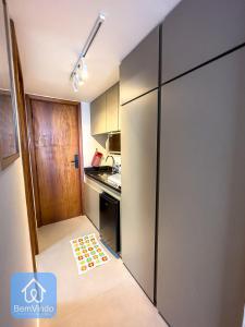 eine kleine Küche mit einem Kühlschrank und einem Teppich auf dem Boden in der Unterkunft Apartamento na Vitória com Pier e acesso ao mar in Salvador