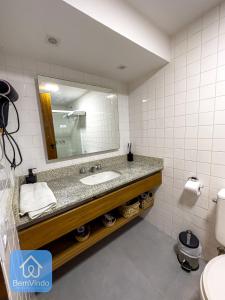 ein Bad mit einem Waschbecken und einem Spiegel in der Unterkunft Apartamento na Vitória com Pier e acesso ao mar in Salvador