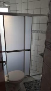 a bathroom with a toilet and a shower stall at Apartamento em Itanhaém com 2 quartos, Piscina e Ampla Varanda Gourmet in Itanhaém