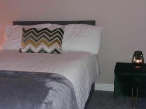 a bedroom with a bed with a pillow and a table at Dún Eoin Carrigaline in Carrigaline