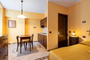 a bedroom with a kitchen and a table and chairs at Agriturismo Edoardo Patrone in Domodossola