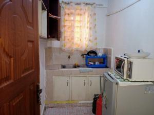 a small kitchen with a microwave on top of a refrigerator at Chaka Airbnb. in Nyeri