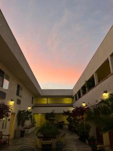 an empty courtyard of a building with a sunset at Airport Inn in South San Francisco