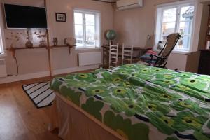 a bedroom with a bed with a flowered blanket on it at Remarkable Harbour View Cabin. in Östhammar