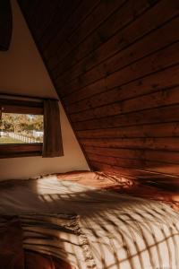 Cama en habitación con ventana en Bohema, en Sierpnica