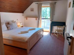 een slaapkamer met een groot bed en een raam bij Apartma Hkavc Markež in Bohinj