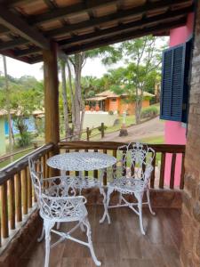 a patio with tables and chairs on a balcony at Pousada Cheiro da Terra in Cunha