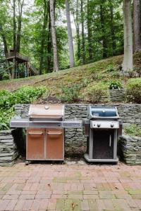 twourgers and a grill sitting on a brick patio at Private estate apartment. in Glen Head