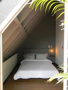 a bedroom with a bed under a roof at Soy Local Parque La 93 in Bogotá