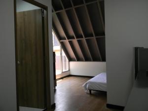 an attic room with a bed and a wooden floor at Soy Local Parque La 93 in Bogotá