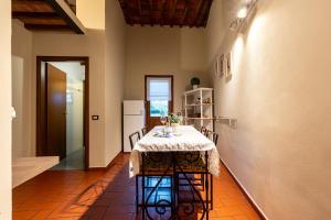 een eetkamer met een tafel en een koelkast bij Apartment Anfiteatro in Lucca