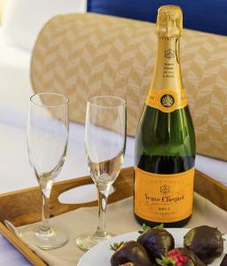 een fles champagne en twee glazen op een dienblad bij Inn at Glencairn in Princeton