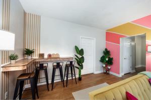 a living room with a kitchen with a bar with stools at Your UF Getaway: 1 Block from Campus - 4 BD Haven in Gainesville