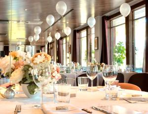 a dining room with a table with glasses and flowers at Beach Hotel Santalahti in Kotka