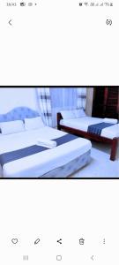 two beds sitting next to each other in a room at Chloe Isla Apartment Malindi. in Malindi
