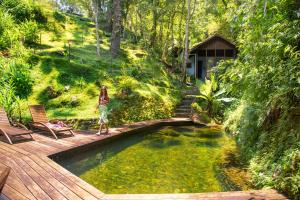 uma mulher está ao lado de uma piscina de água em Pousada Tijupá em Visconde de Mauá