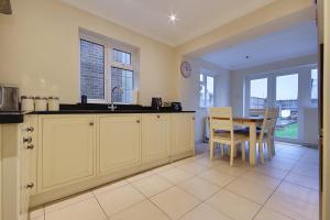 a kitchen with a sink and a table and chairs at The Wendy House in Bournemouth