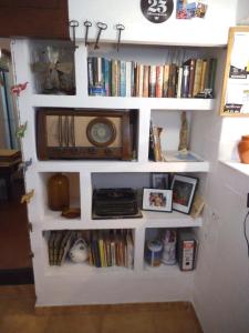 a book shelf with a clock and books at Casa de Huespedes la Peña in Ibiza Town