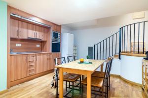 Una cocina y un comedor con mesa y sillas de madera. en Elena Apartments - Girona, en Girona