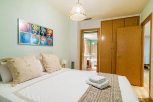 Un dormitorio con una gran cama blanca con dos toallas encima. en Elena Apartments - Girona, en Girona