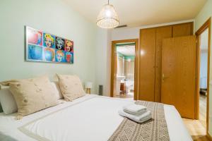 a bedroom with a large white bed with two towels on it at Elena Apartments - Girona in Girona